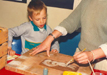 Painting slip decoration onto a ceramic tile at Bloomin Arts pottery workshop run by Crackpots CAO