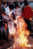 children throw sawdust onto the red hot pots as part of the raku process
