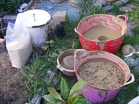A bag of sawdust with the mixing bucket, seive and bucket with the final clay sawdust mix