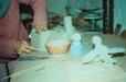 photo showing a potter at work on a ceramic piece