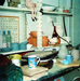 photo of the studio showing a work bench and shelves stacked with wares in various stages of production